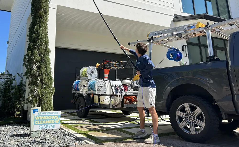 Surf Window Cleaning technician loading equipment at the company truck
